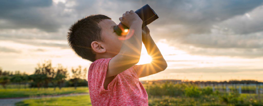 boy looking through binoculars at the sky